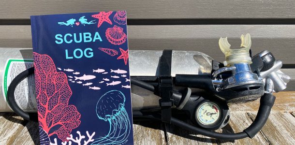 A Scuba Diving Logbook And A Pony Bottle Tank