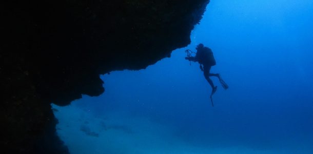 Ali Scuba Diving Silhouette Coming Out Of A Cave On Lanzarote, Canary Island, Spain
