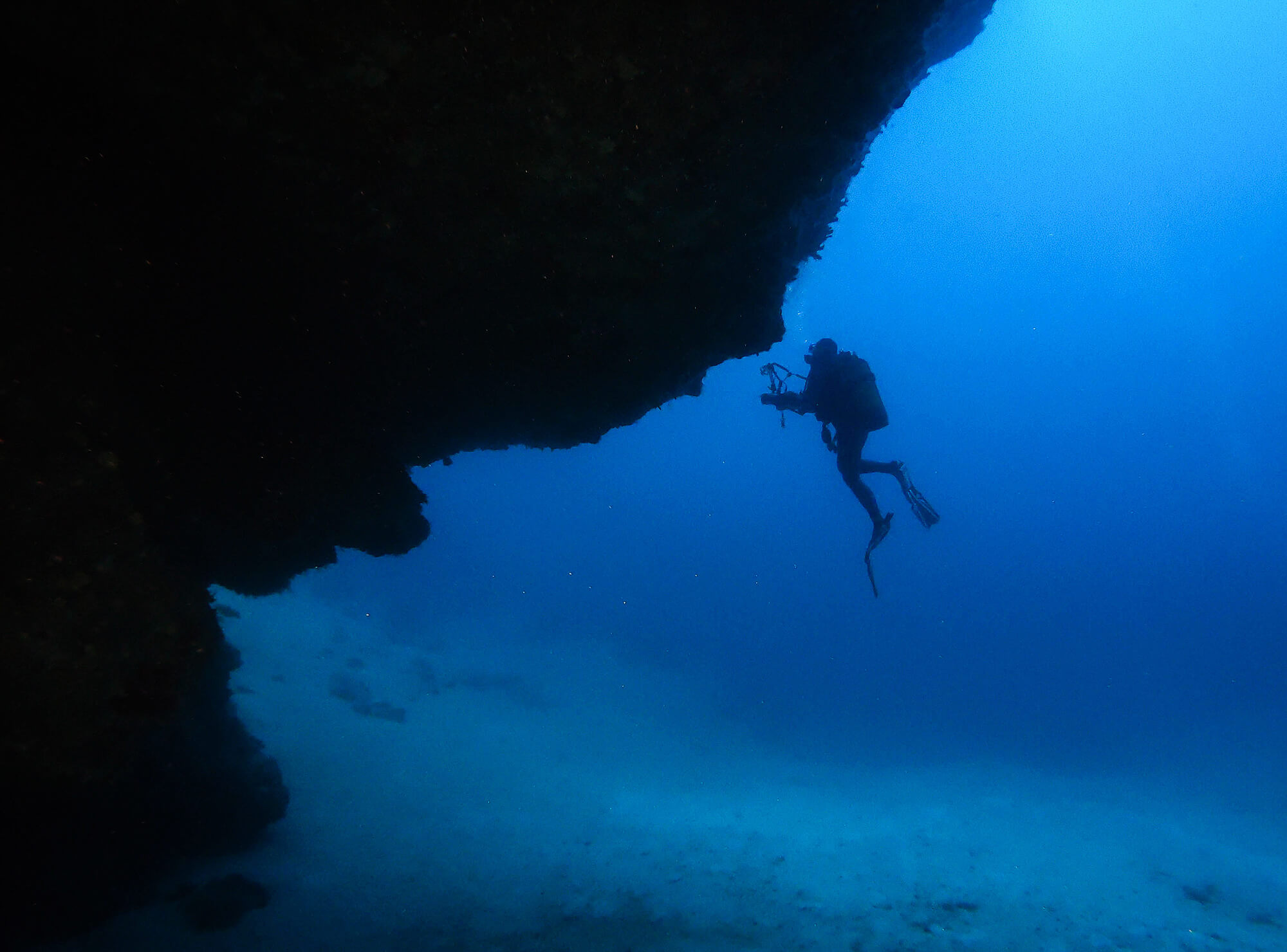 Ali Scuba Diving Silhouette Coming Out Of A Cave On Lanzarote, Canary Island, Spain