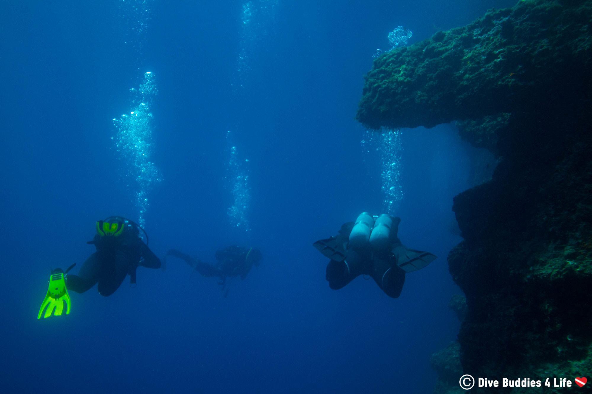 Three Scuba Divers Swimming At A Deep Scuba Diving Site In Dubrovnik, Croatia